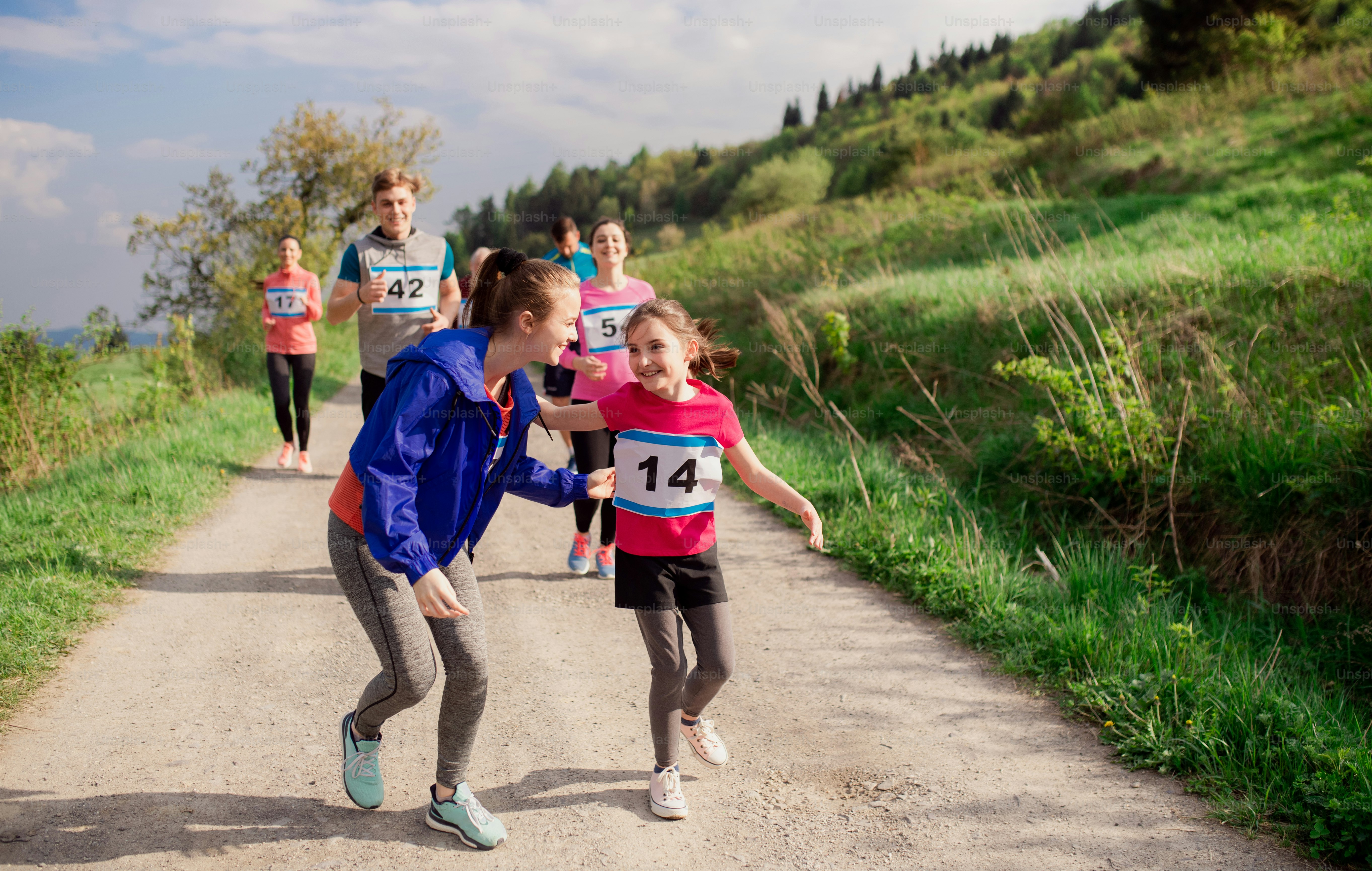 A large group of active multi generation people running a race competition in nature