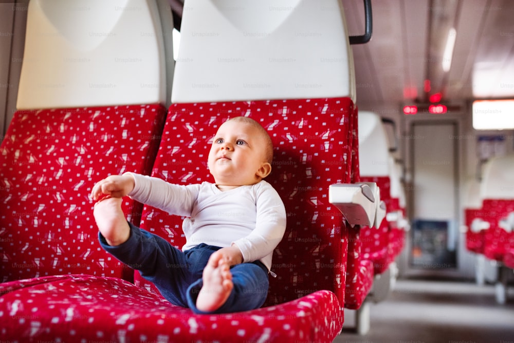 Lindo bebé que viaja en tren. Viaje en tren de un niño pequeño.