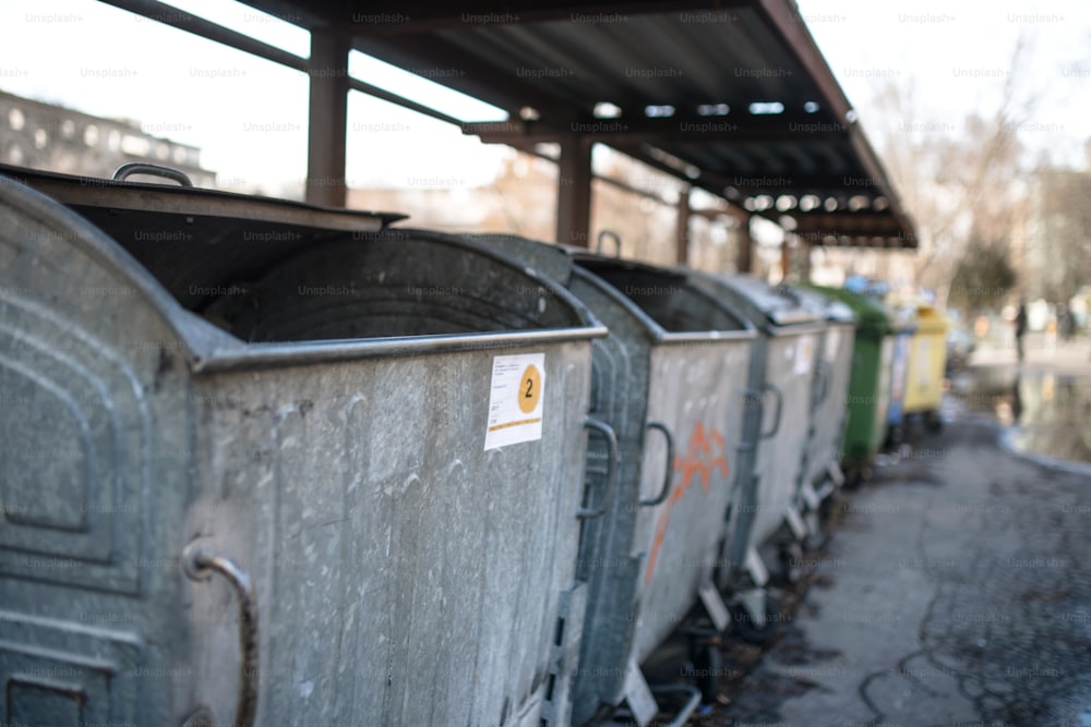 Garbage containers in row on the urban street. Copy space.