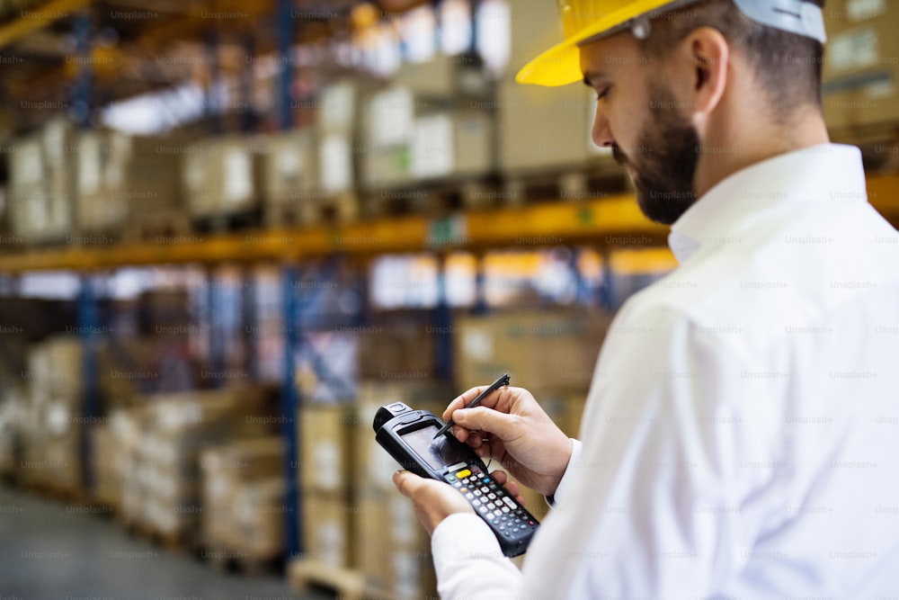 Warehouse worker or supervisor with barcode scanner. A mobile handheld PC with barcode scanner.