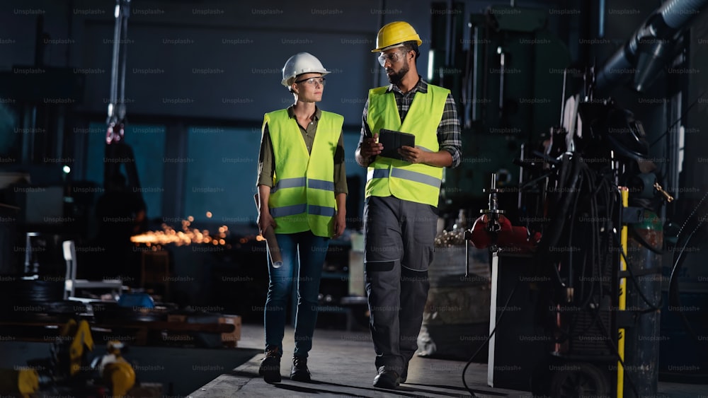 A portrait of young industrial woman working indoors in metal workshop.