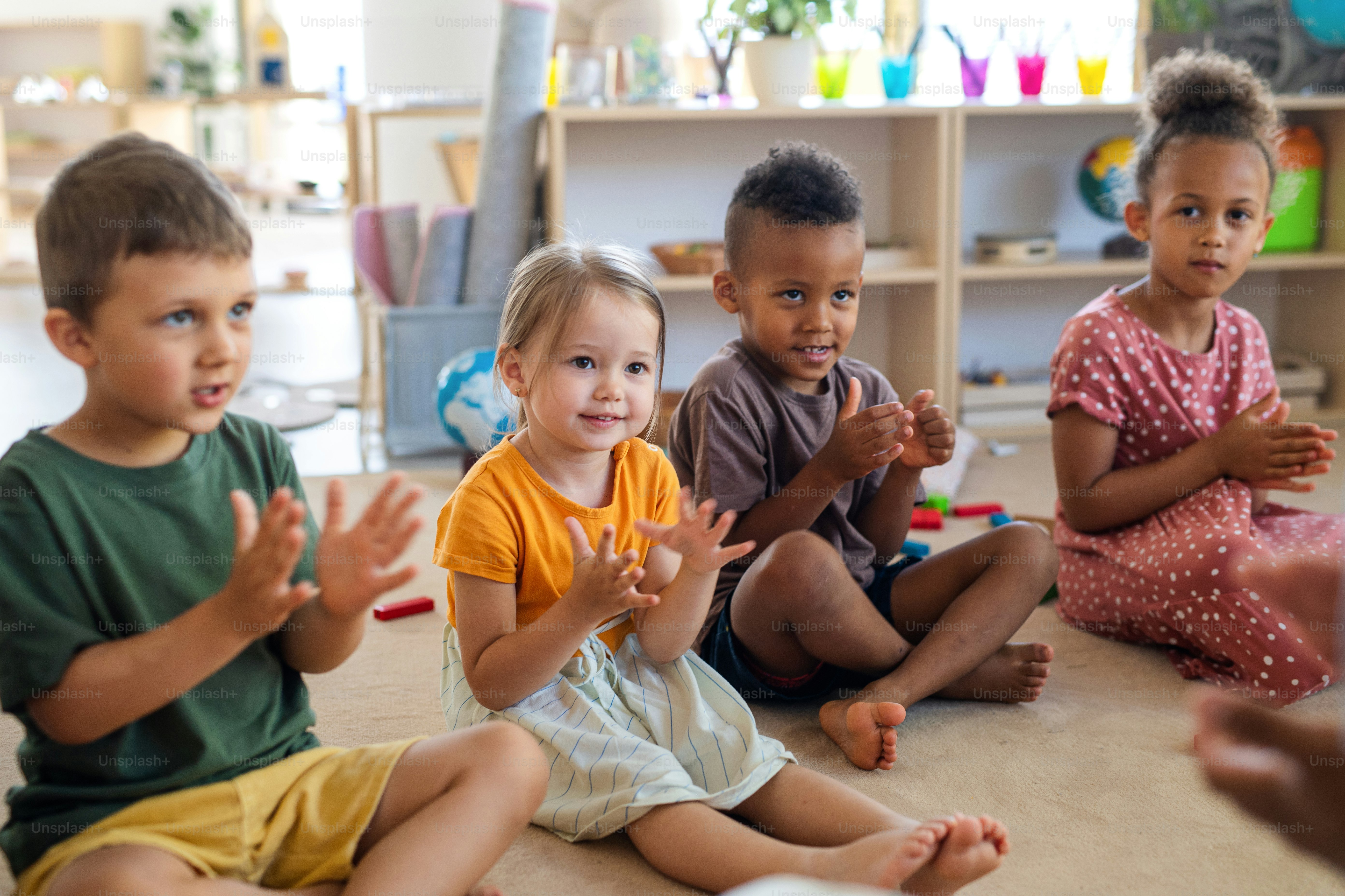 A group of small nursery school children playing indoors in classroom ...