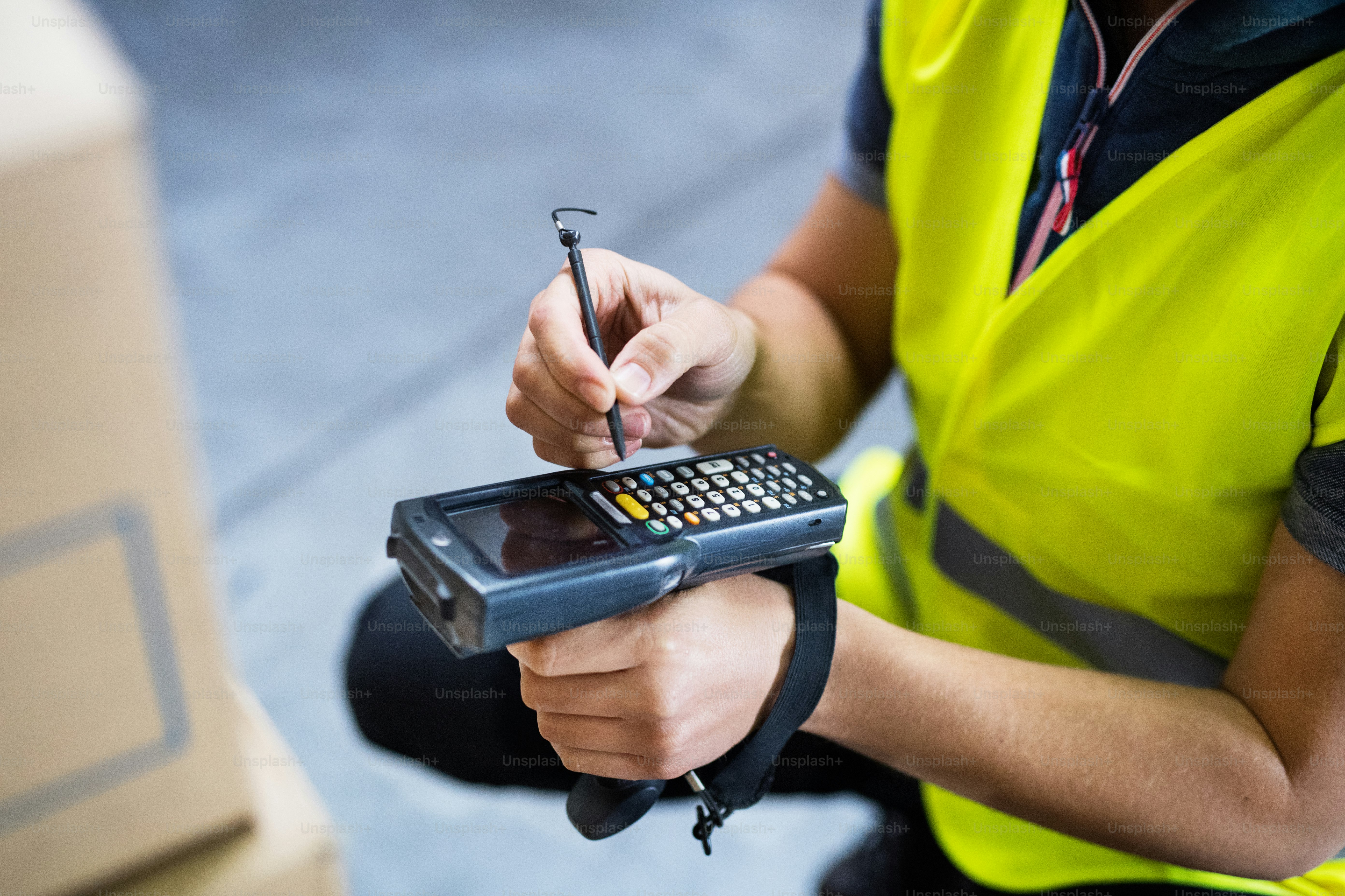 Nicht erkennbarer männlicher Lagerarbeiter mit Barcode-Scanner.