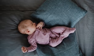 A top view of newborn baby girl, sleeping an lying on sofa indoors at home.