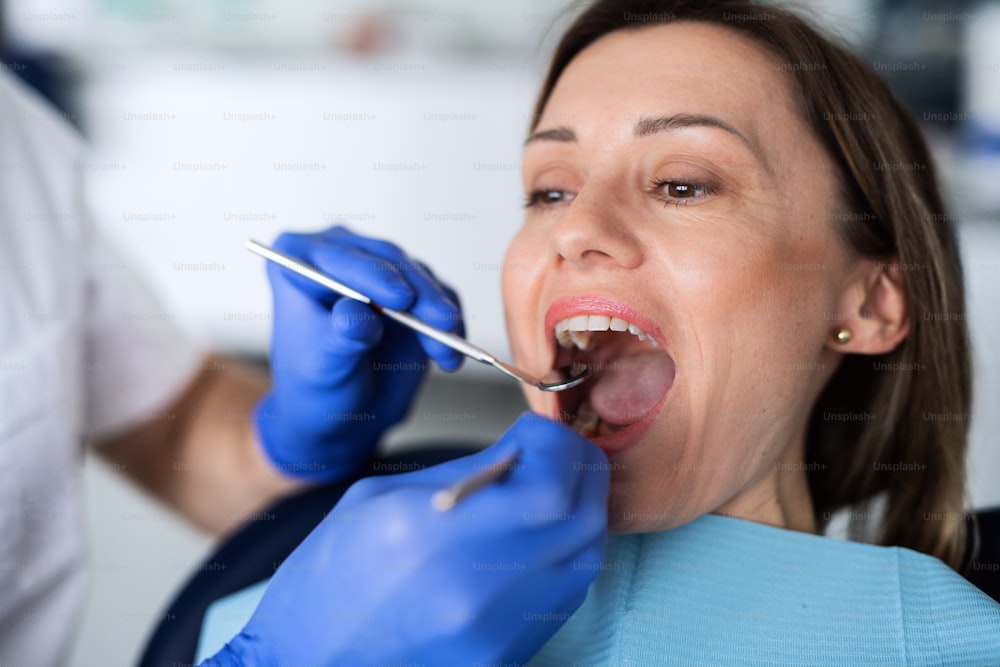Uma mulher tem um check-up odontológico anual em cirurgia de dentista.