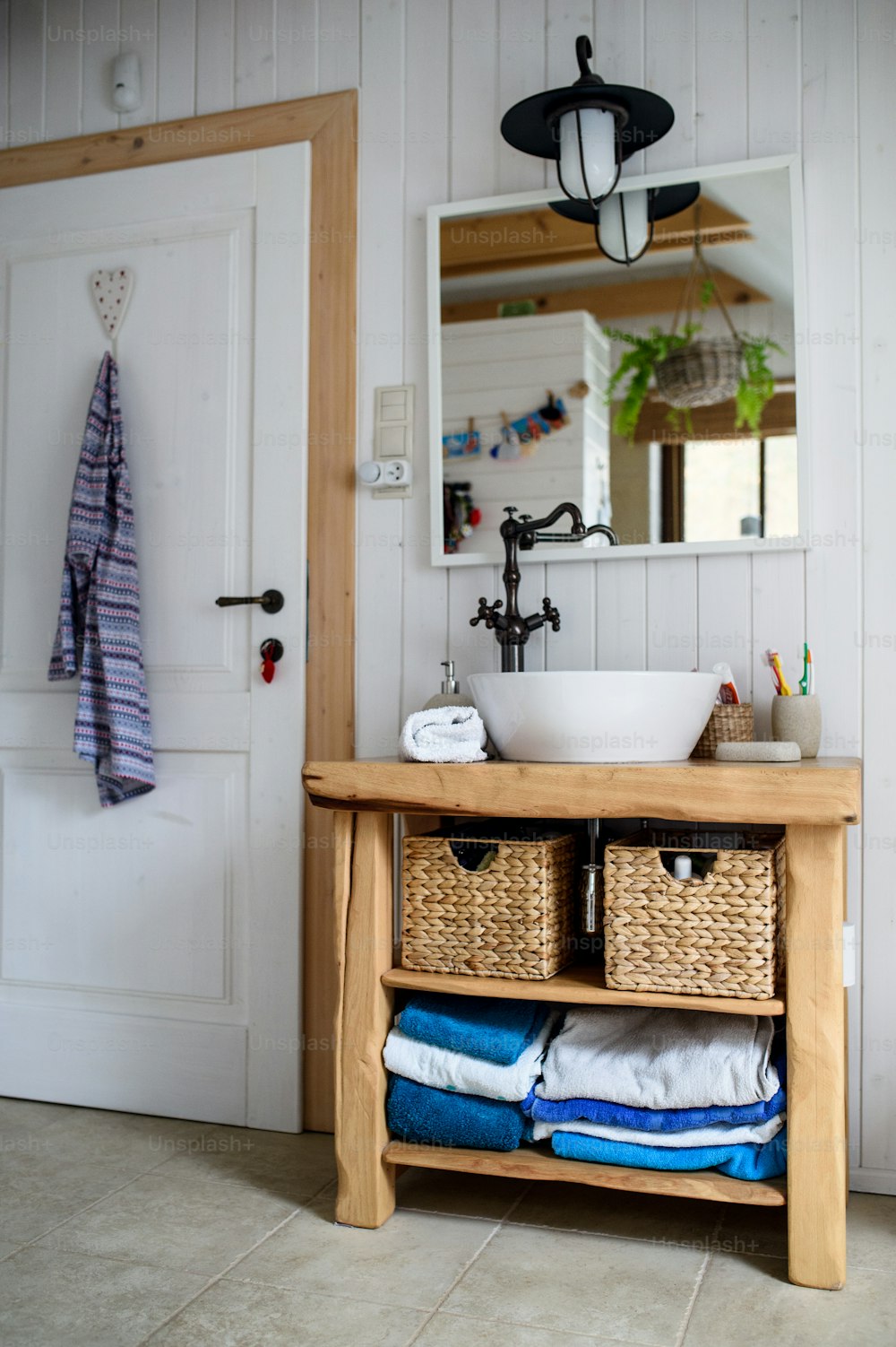 Lavandino, specchio e armadio in legno nel bagno vintage di casa.