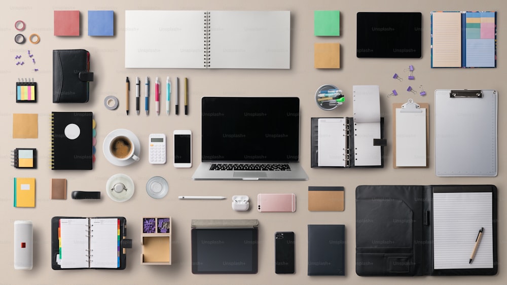 Flat lay top view office desk working space with laptop, tablet, smartphone and supplies on gray background.