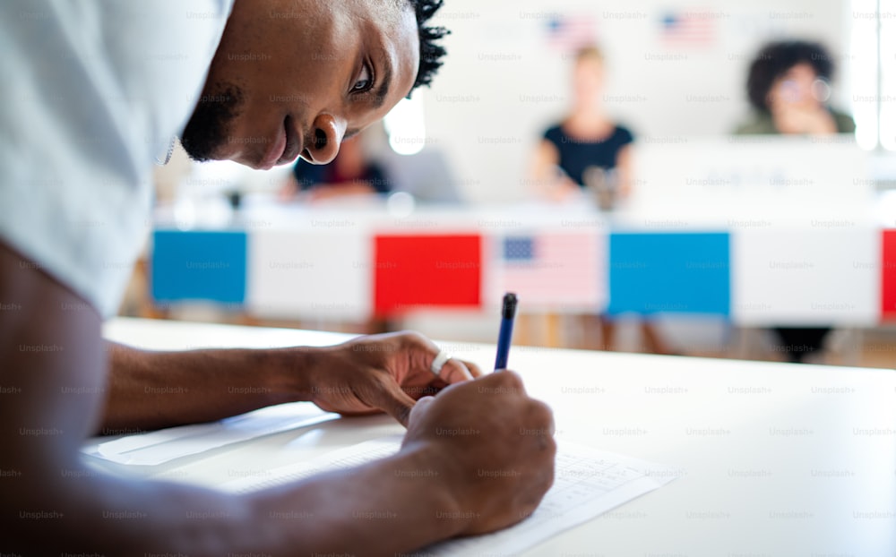 African-american man voter in polling place, usa elections concept, writing.