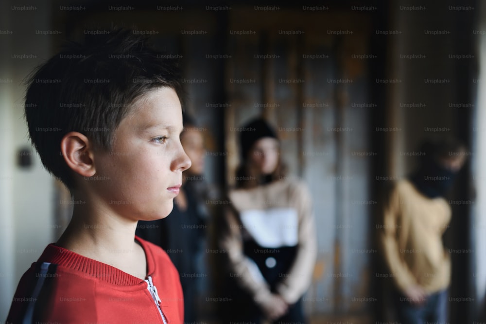 Sad and disappointed teenagers boy indoors in abandoned building, bullying concept. Copy space.