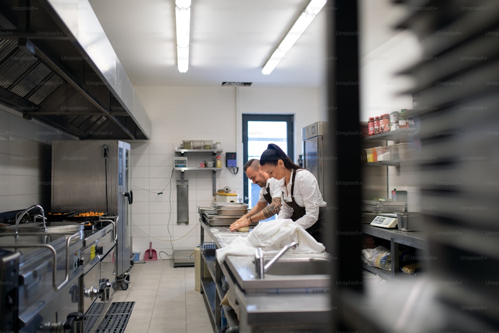 Un chef y un cocinero trabajando en sus platos en el interior de la cocina del restaurante.
