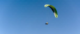 A paraglider in the blue sky. The sportsman flying on a paraglider.