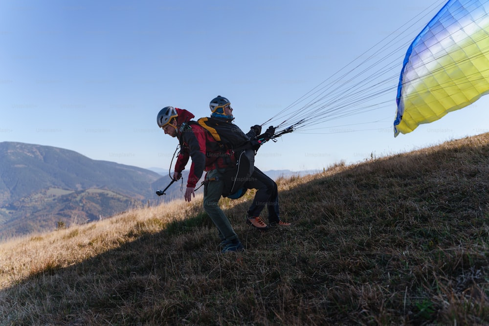 Parapentes preparándose para volar en montaña. Actividad deportiva extrema.