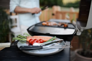 Vegetables on a plate prepared for grilling during weekend barbecue in yard, outdoor.