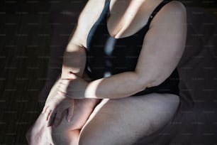 A midsection  woman in underwear sitting.