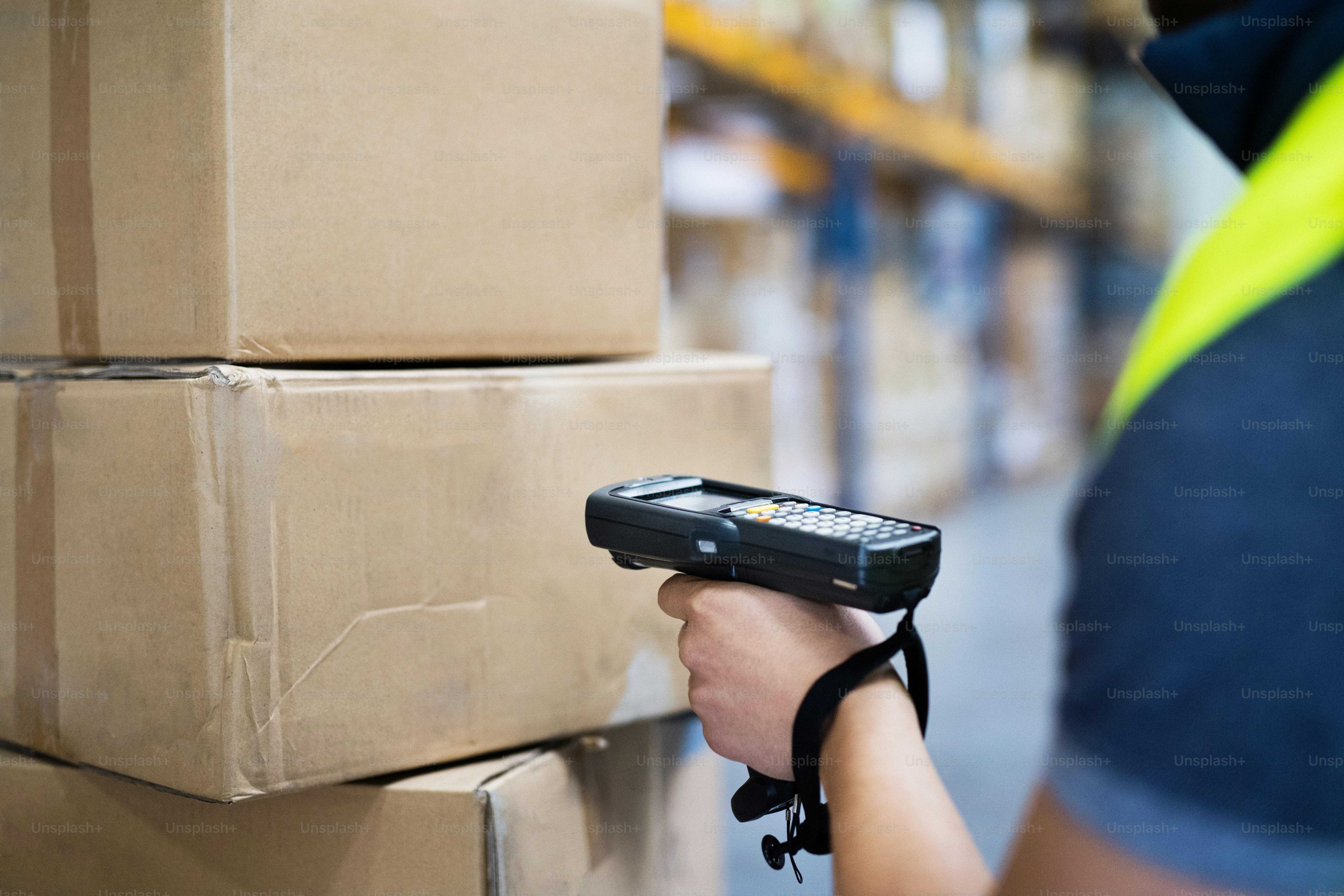 Nicht erkennbarer männlicher Lagerarbeiter mit Barcode-Scanner.
