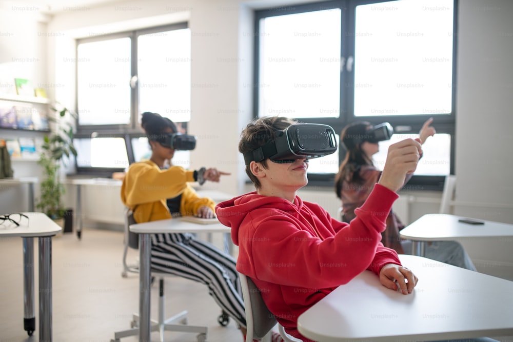 Des adolescents portant des lunettes de réalité virtuelle à l’école dans un cours d’informatique