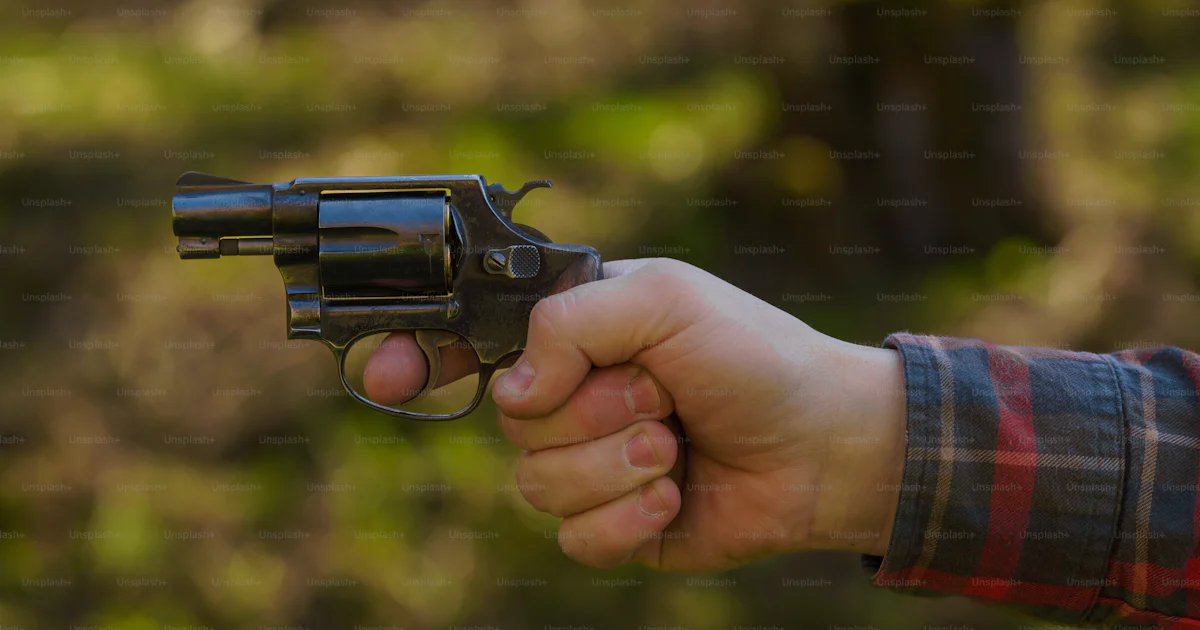 Man With Revolver An unrecognizable man with revolver aiming target on shooting range ...