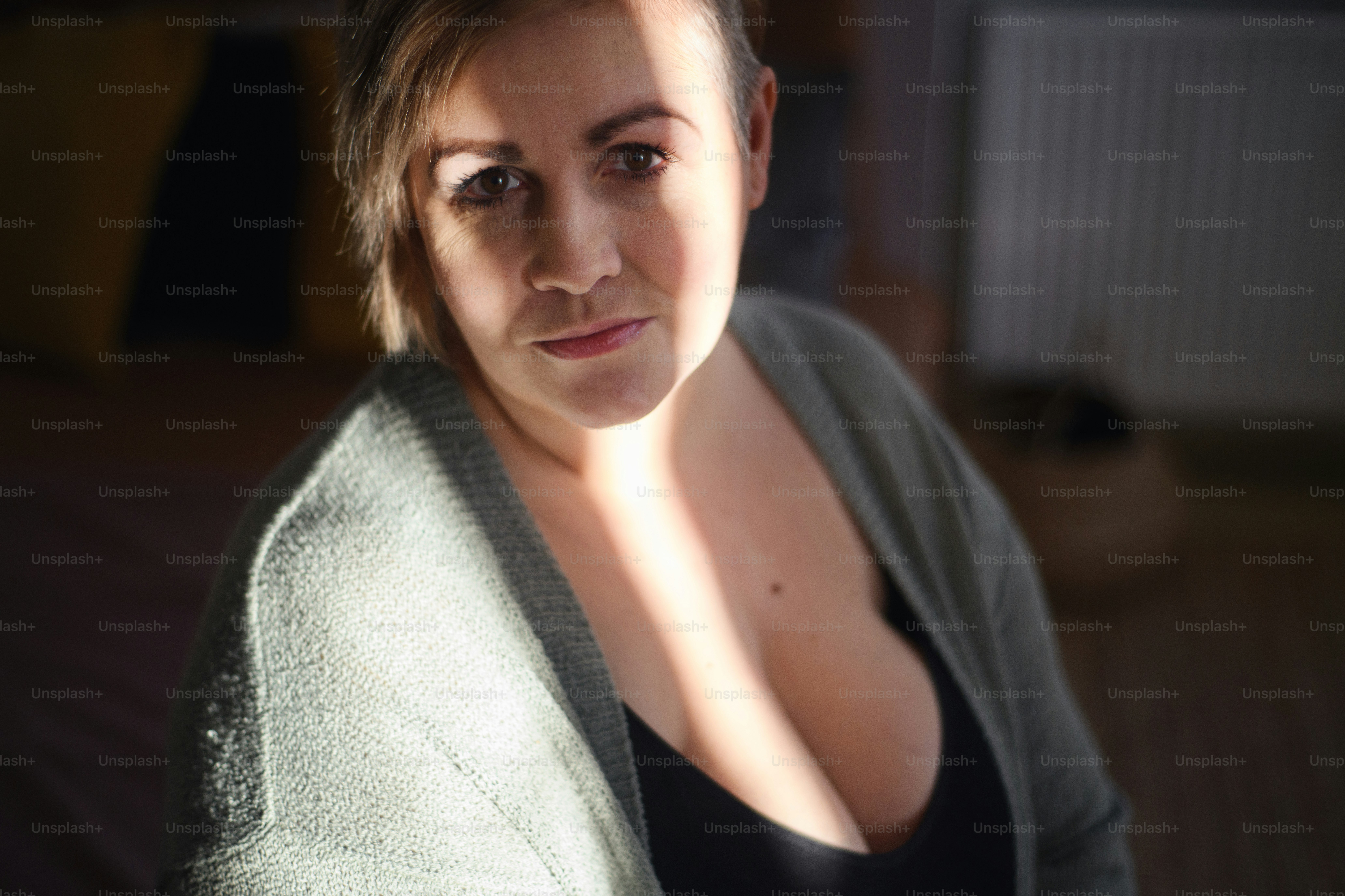 A depressed lonely fat woman in underwear looking down and thinking at home.