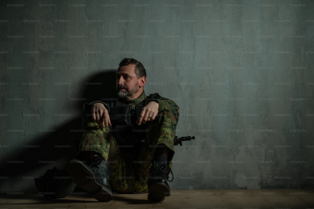 Un soldado militar frustrado sentado en un campo de entrenamiento