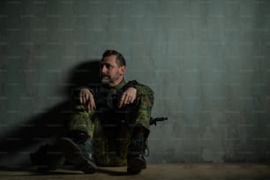 Un soldato militare frustrato seduto in un campo di addestramento