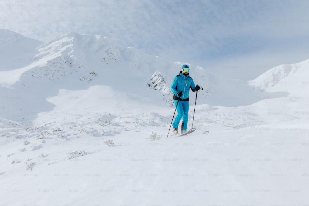 스위스 알프스의 눈 덮인 봉우리 정상까지 하이킹하는 남성 백컨트리 스키 선수