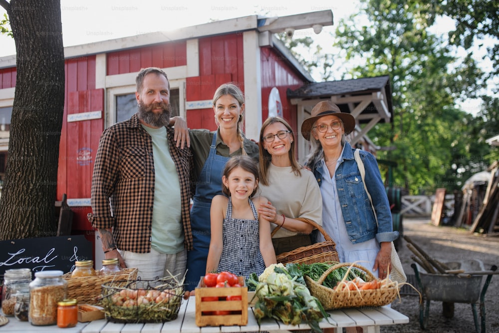 A family of farmers selling homegrown products at community farmers market, looking at camera.