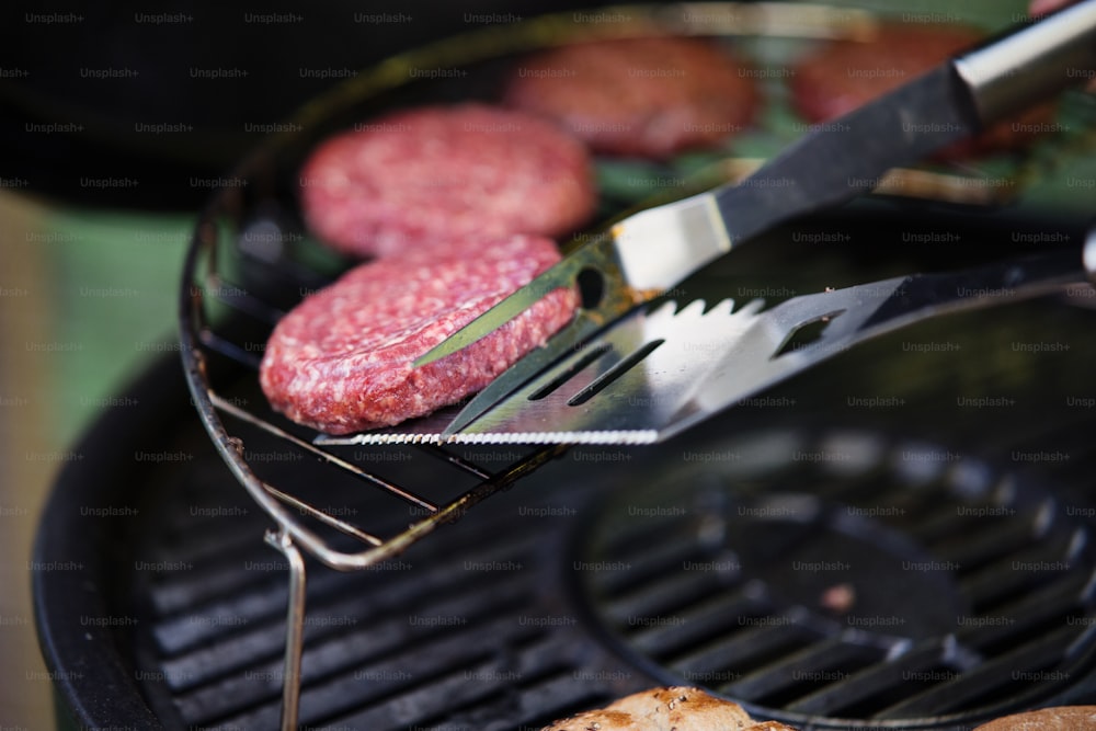A close up of barbecue grill with burgers on it.