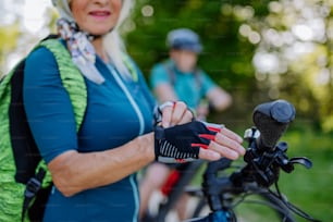 Primo piano di una motociclista anziana che indossa guanti da bicicletta.