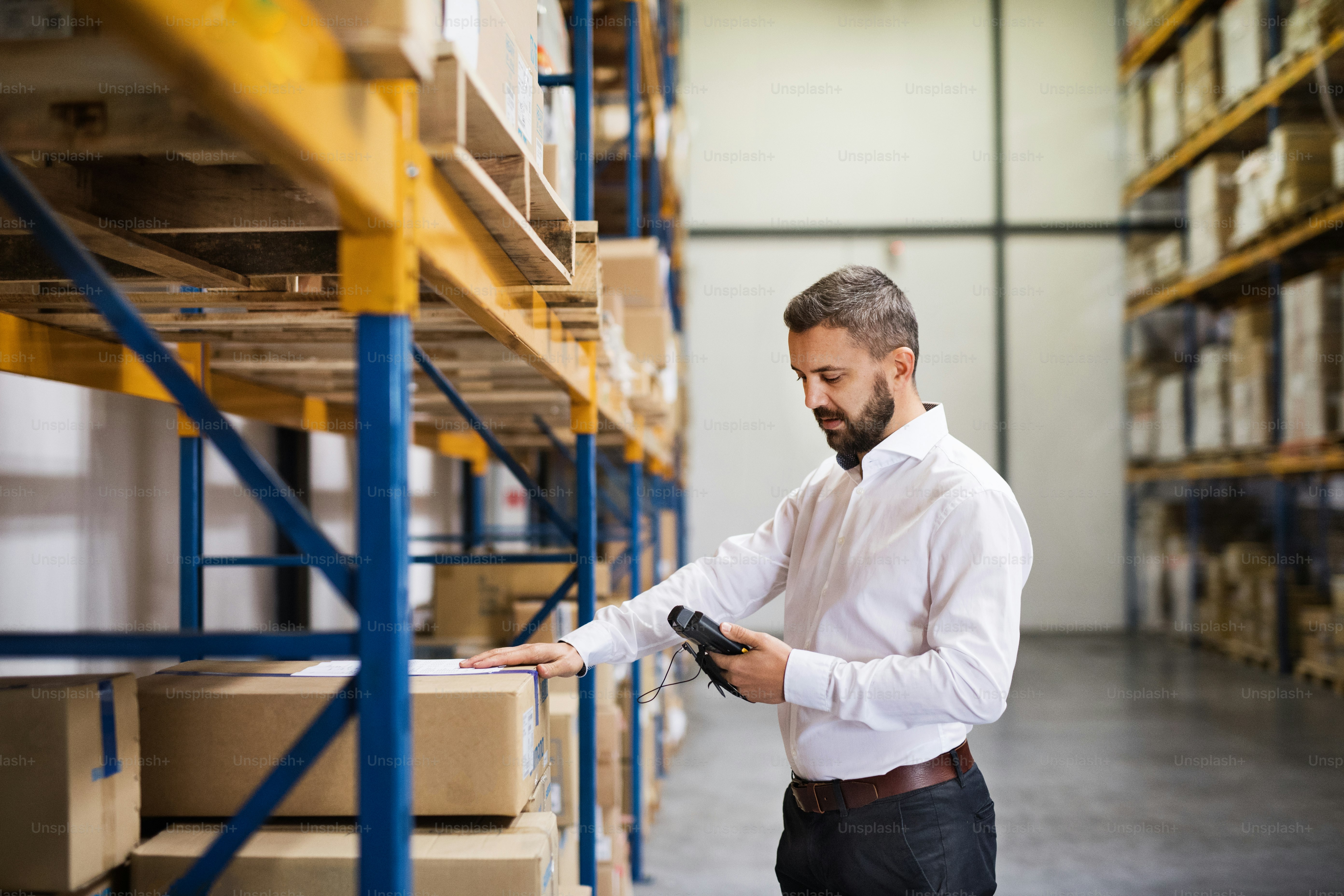 Warehouse worker or supervisor with barcode scanner. A mobile handheld PC with barcode scanner