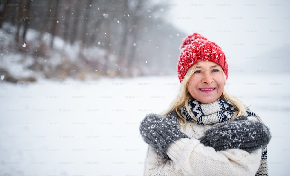 Front view portrait of happy senior woman with hat and mittens outdoors  standing in snowy nature. photo – Nature Image on Unsplash