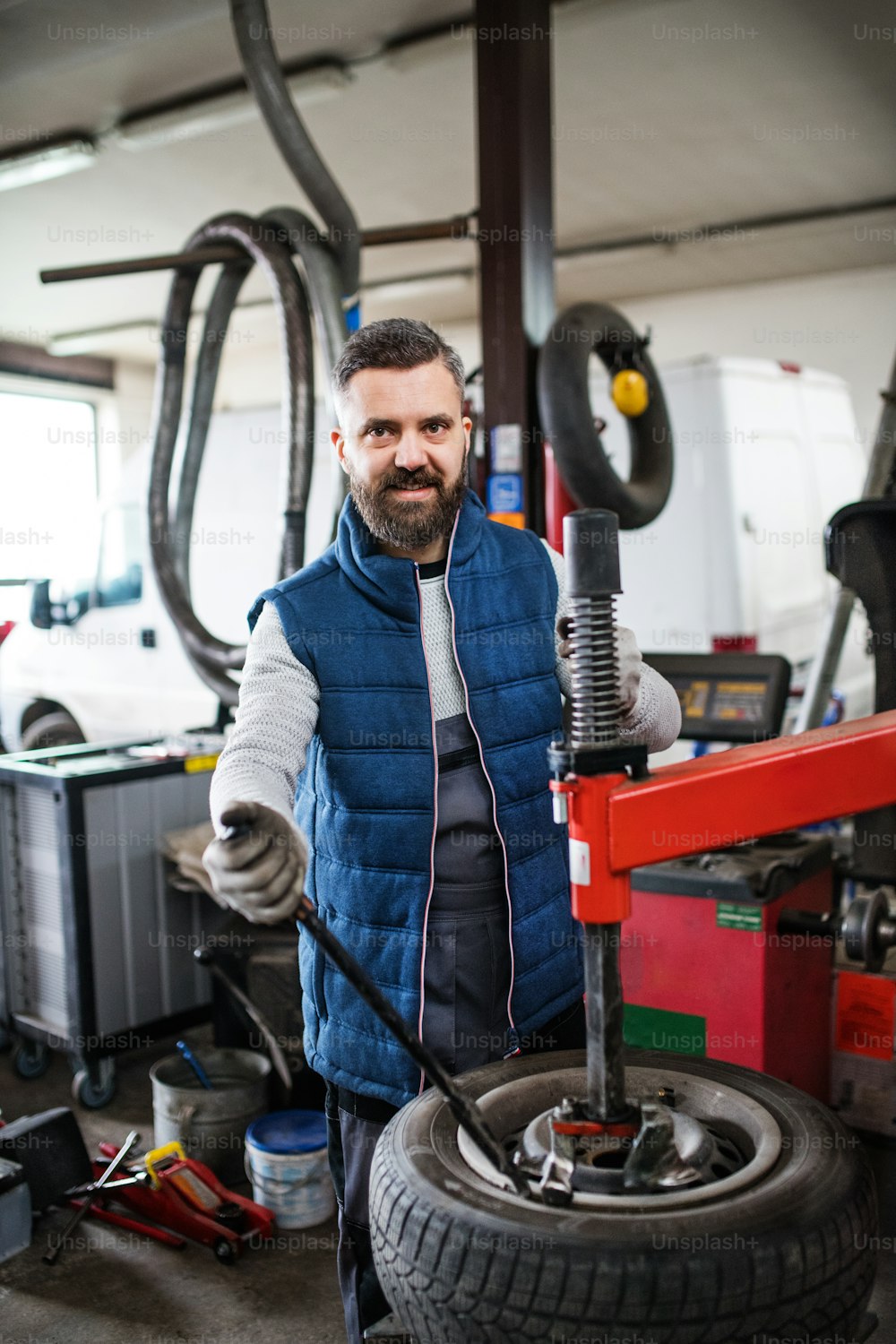 Mature man mechanic repairing a car in a garage.