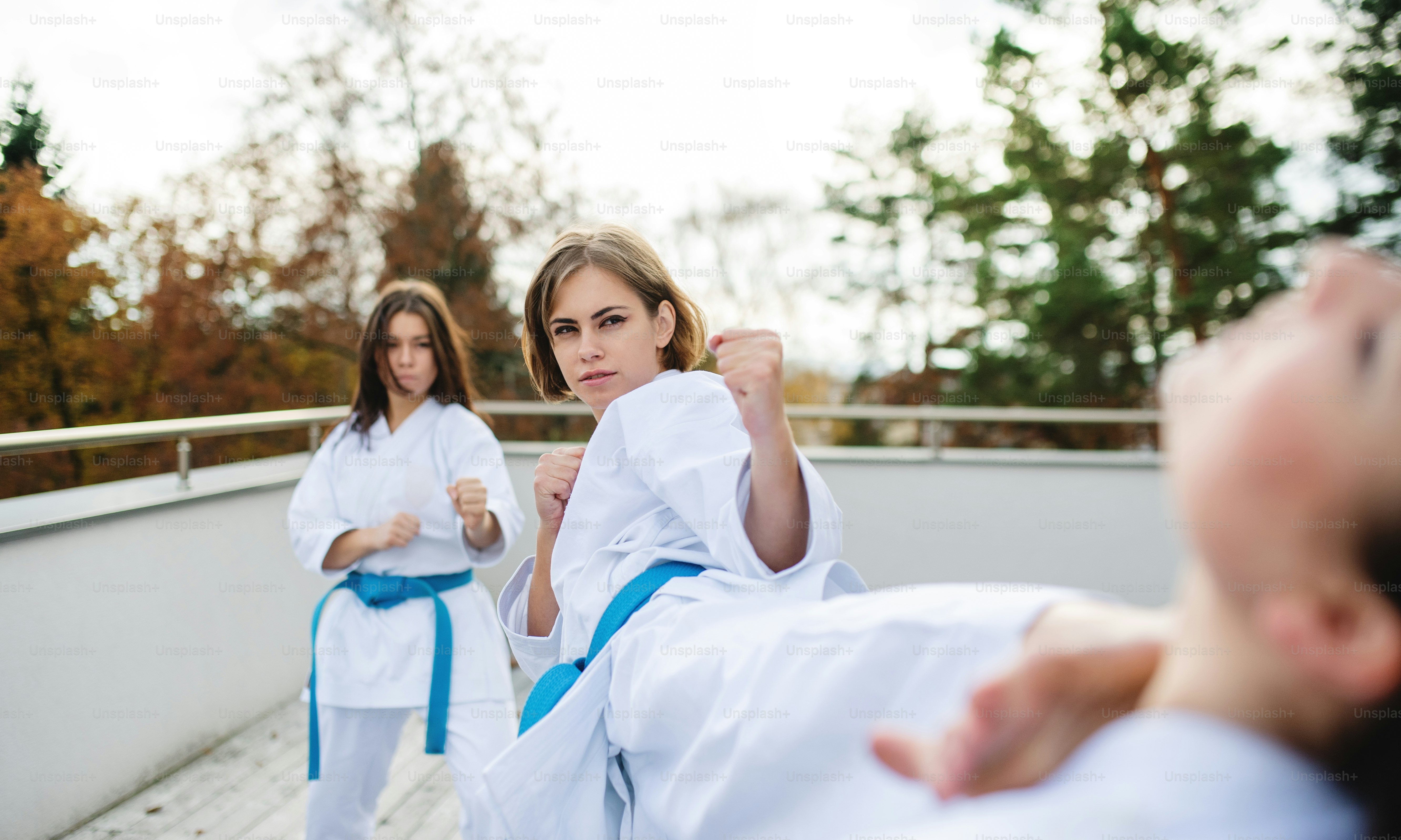 Un gruppo di giovani donne che praticano karate all'aperto su una terrazza.