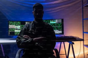 An anonymous hacker in military unifrorm on dark web, cyberwar concept.