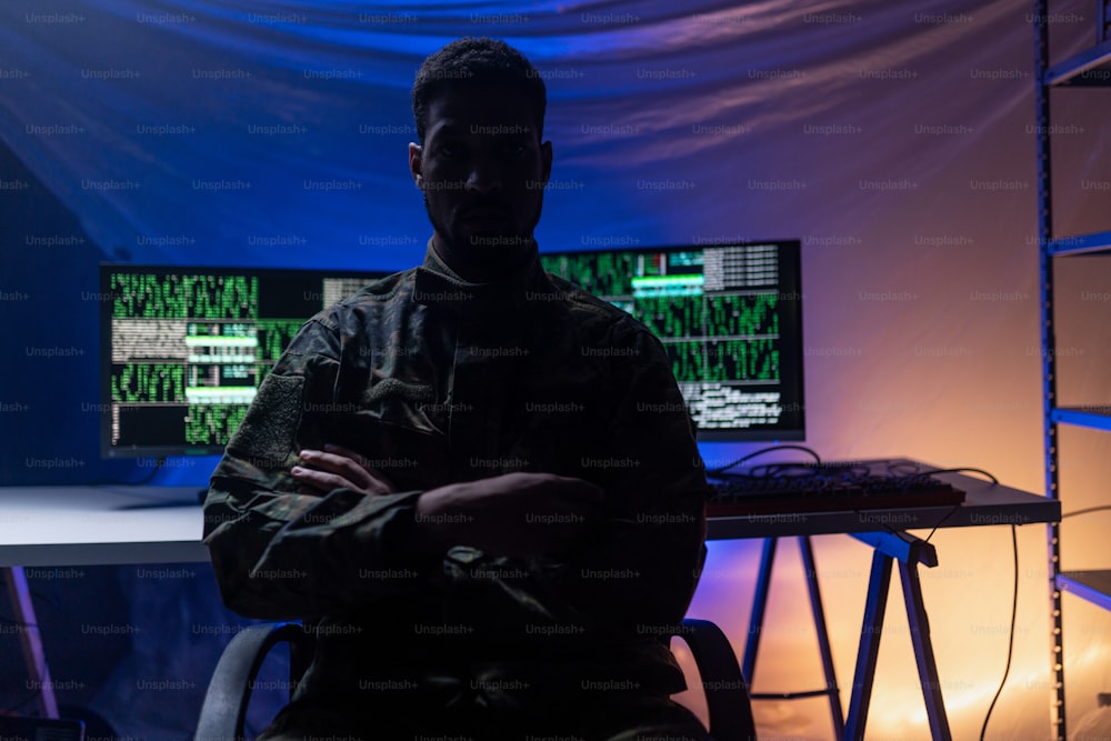 An anonymous hacker in military unifrorm on dark web, cyberwar concept.