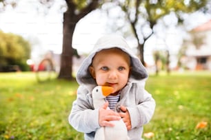 Cute baby boy on the grass in the garden. Toddler playing in nature. Close up.