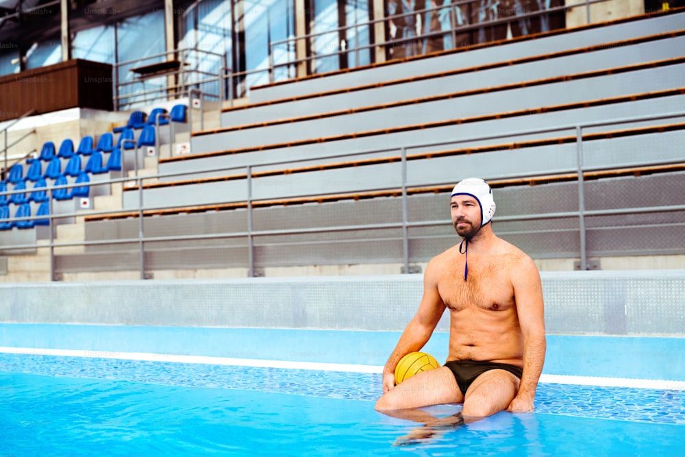 Water polo player in a swimming pool. Man doing sport.
