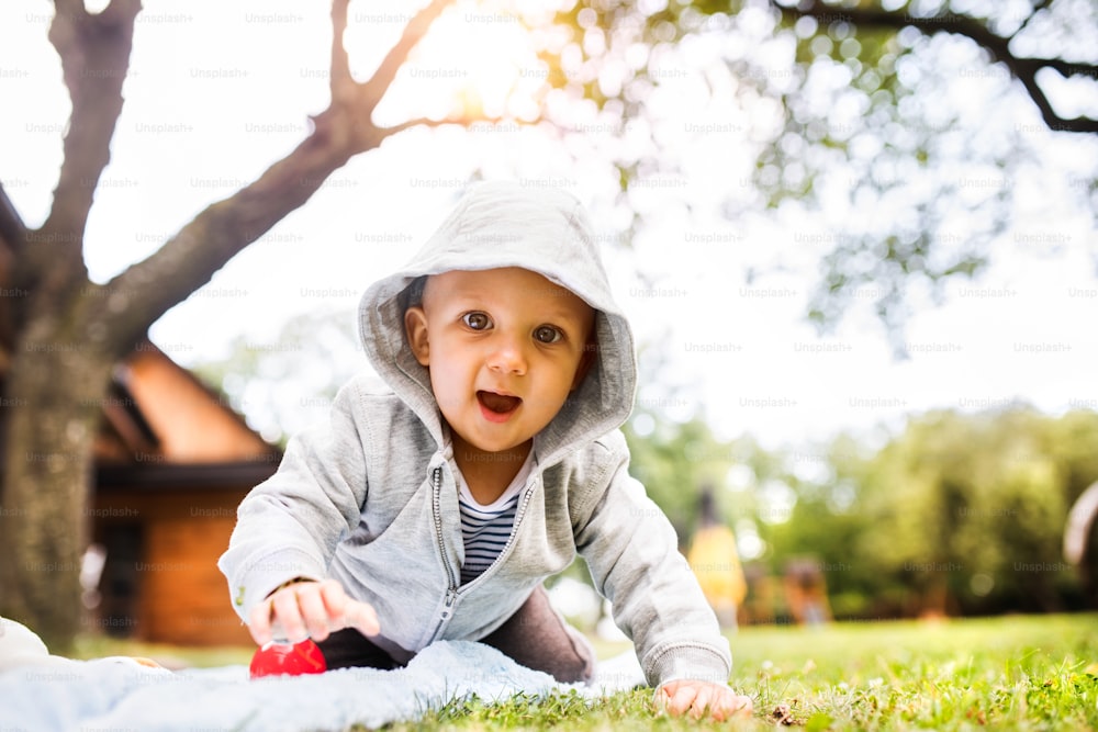 Bambino carino sull'erba in giardino. Bambino che gioca nella natura.