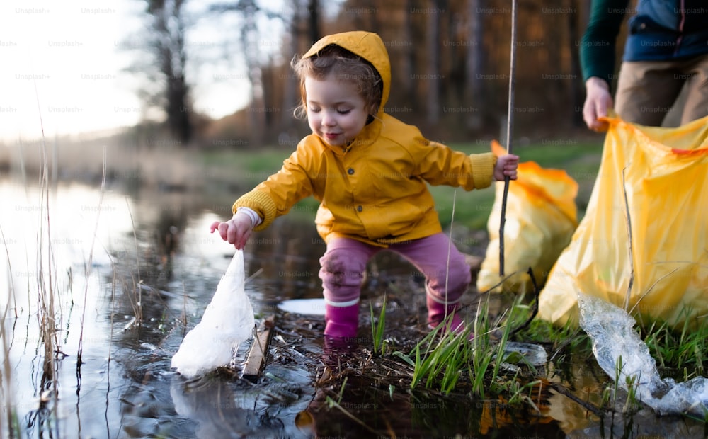 Unrecognizable father with small daughter working outdoors in garden, sustainable lifestyle concept.