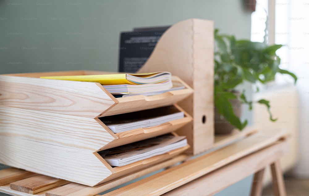 Portavassoi e organizer in legno per carta e documenti sulla scrivania con concetto di decorazione vegetale e naturale.
