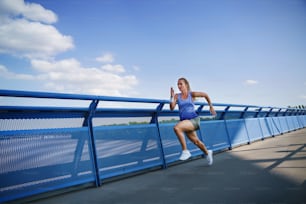 A mid adult woman running outdoors in city, healthy lifestyle concept.