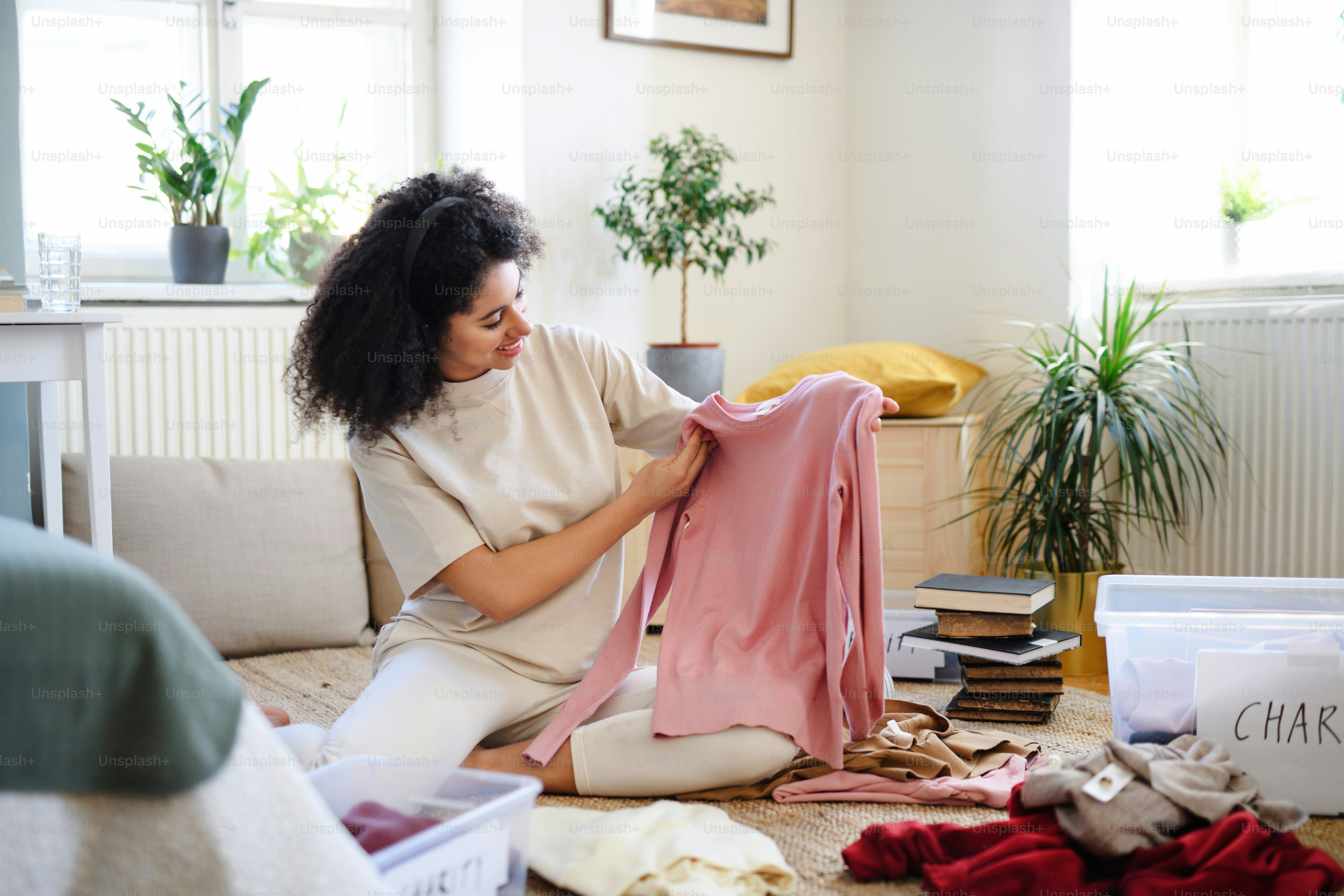 Happy young woman sorting wardrobe indoors at home, charity donation ...