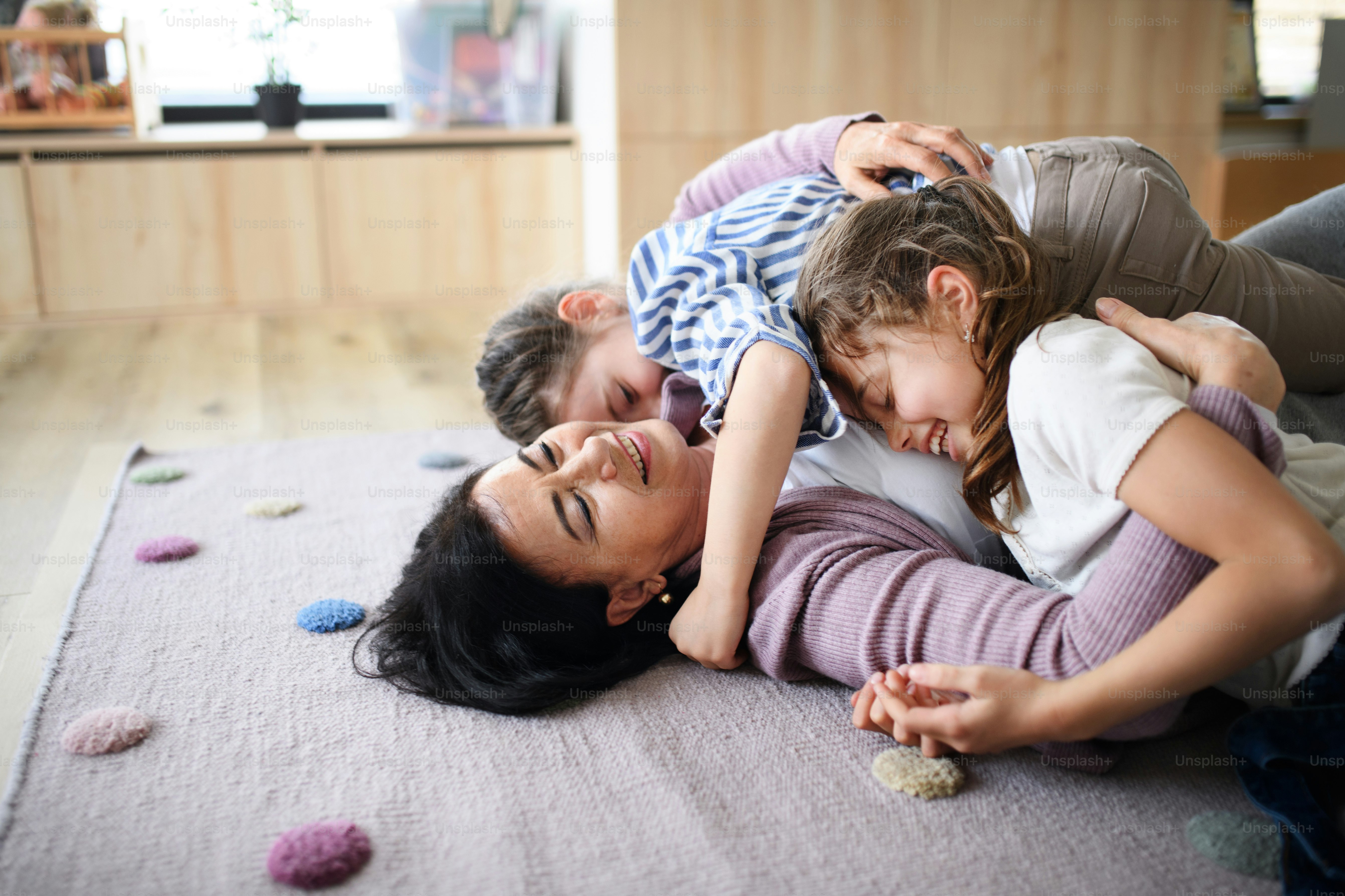 Foto Niñas pequeñas felices con abuela mayor en el interior de la casa ...