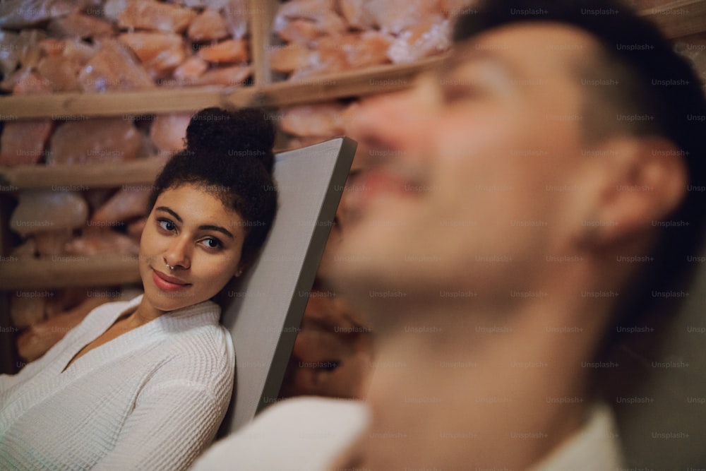 Retrato de una pareja joven feliz en la sala de vapor de inhalación de sal, relajante.