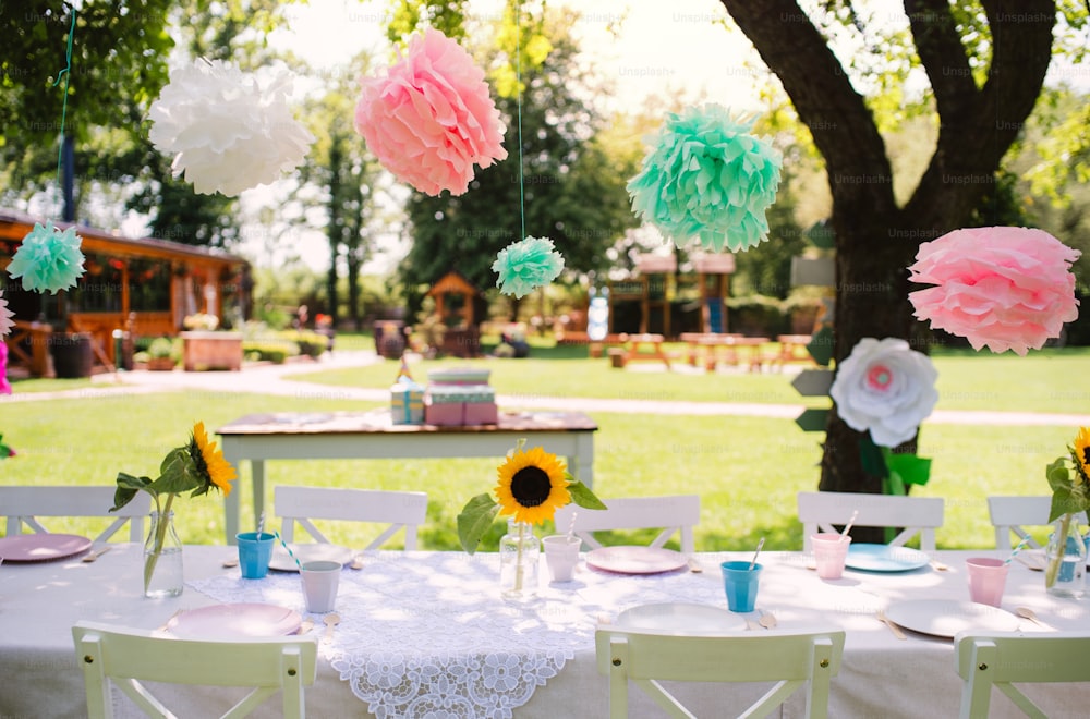 Un set da tavola per la festa di compleanno dei bambini all'aperto in giardino in estate, concetto di celebrazione.