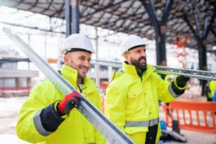 Men workers walking outdoors on construction site, working in winter.