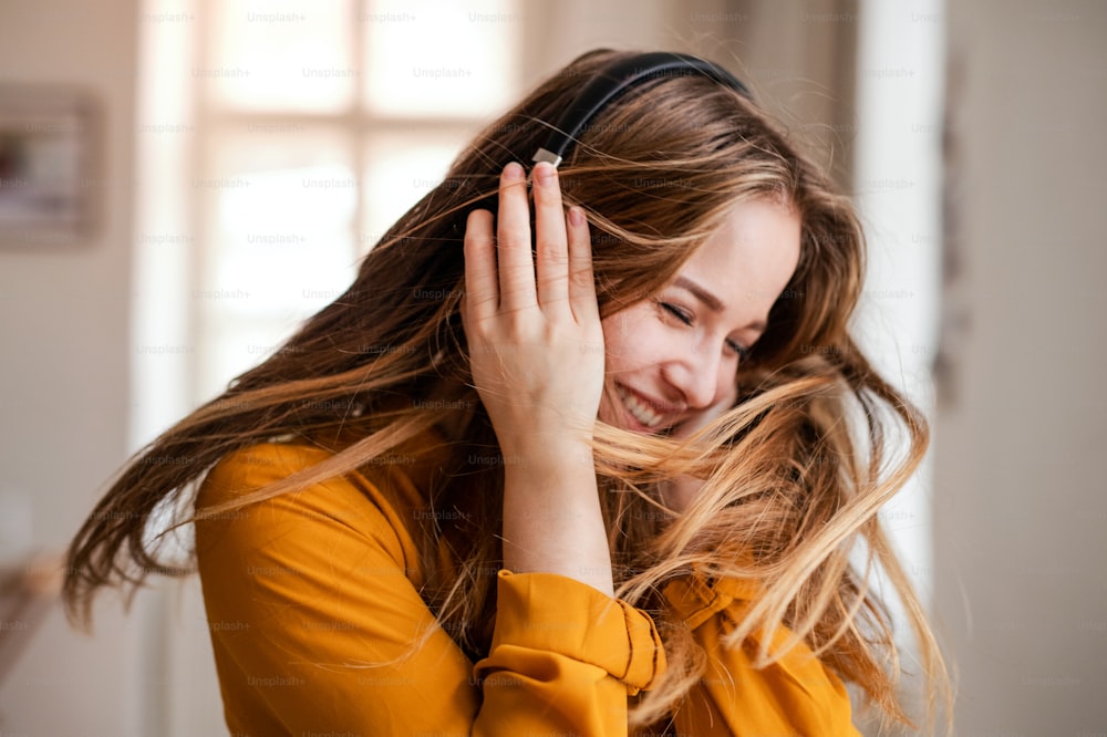 A happy young female student with headphones having fun.