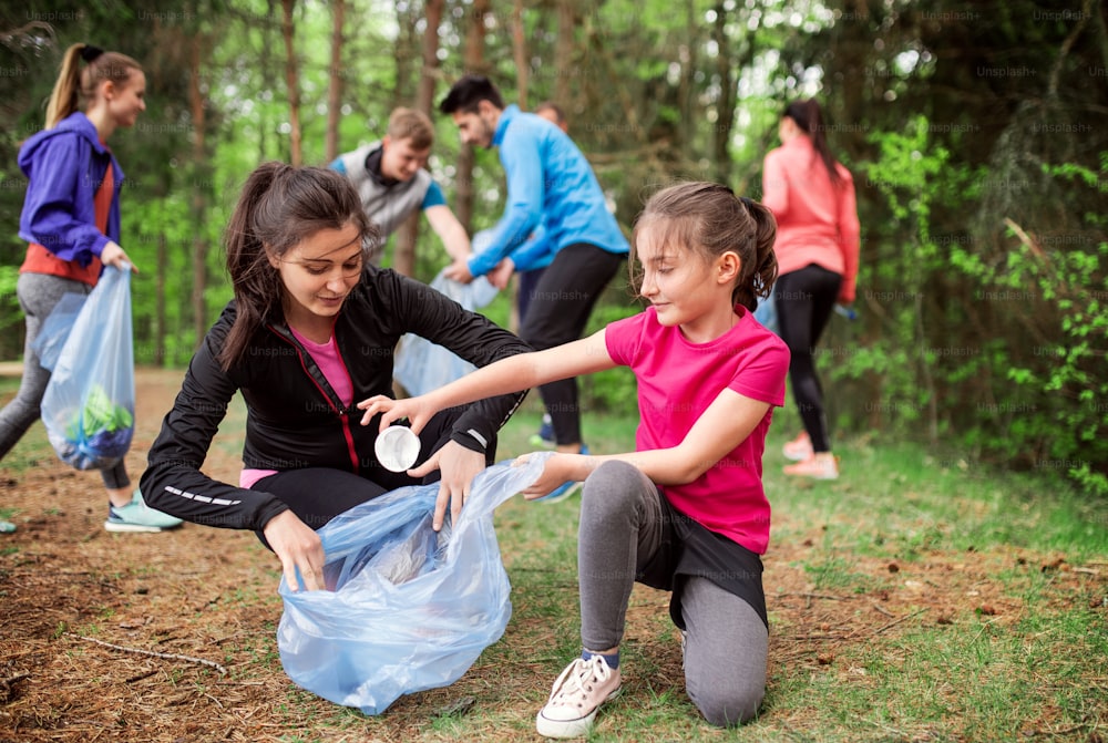 Un gruppo di giovani attivi che raccolgono rifiuti in natura, un concetto di plogging.