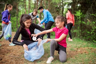 Un groupe de jeunes actifs qui ramassent des déchets dans la nature, un concept de plogging.