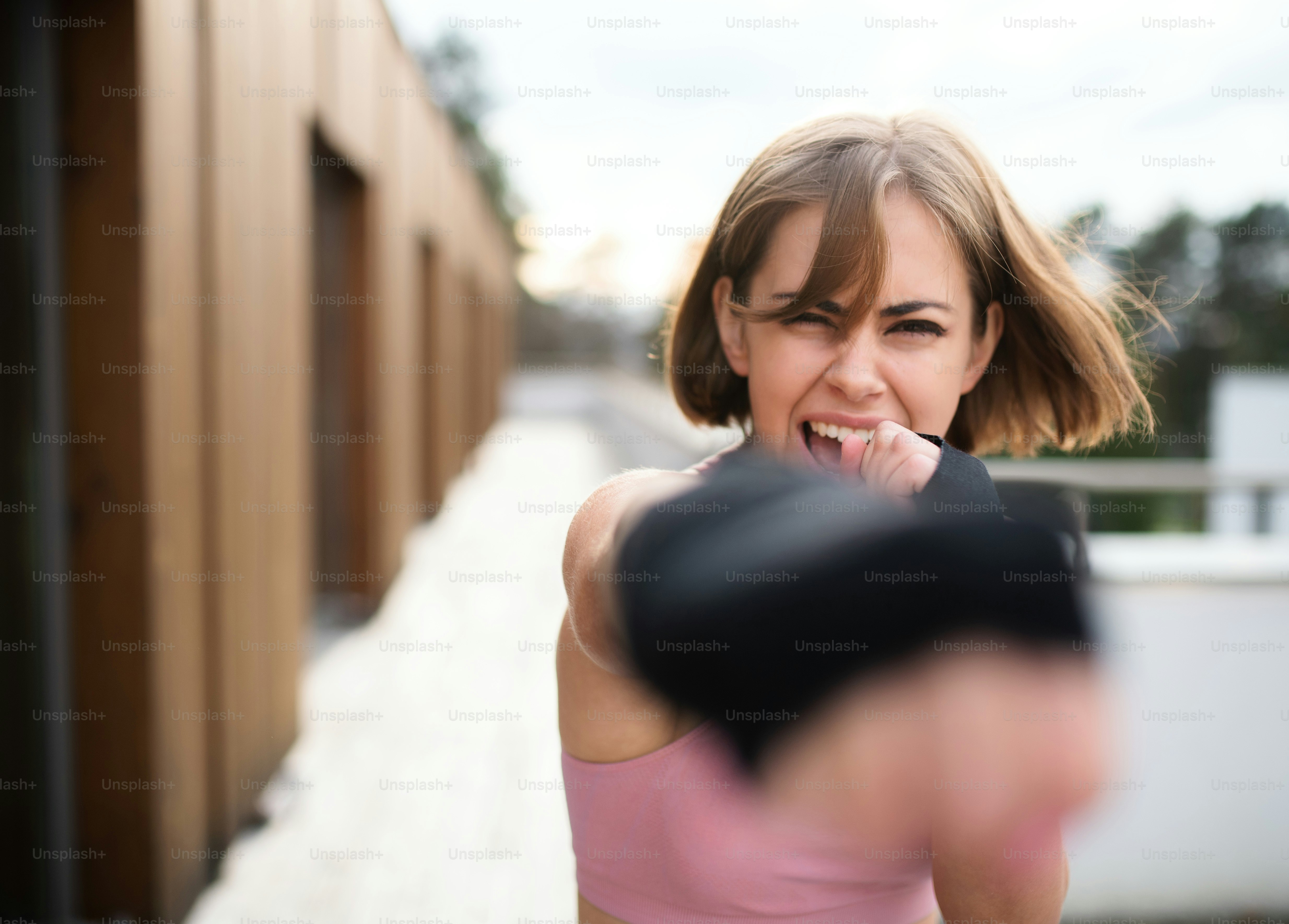 Vue de face d’une jeune femme pratiquant le karaté en plein air sur la terrasse