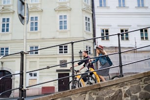 Young tourist couple travellers with electric scooters in small town, sightseeing.